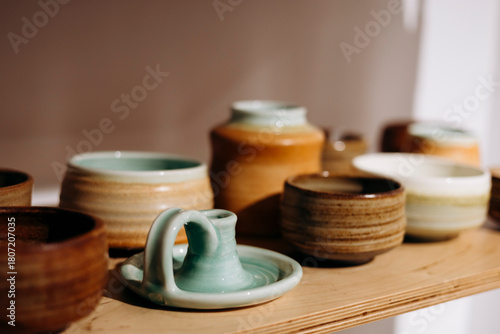 Handmade candle holder and tableware on store shelf for gift.