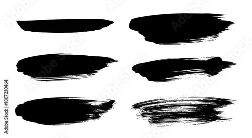 A collection of six different black grunge brush strokes isolated on a white background.