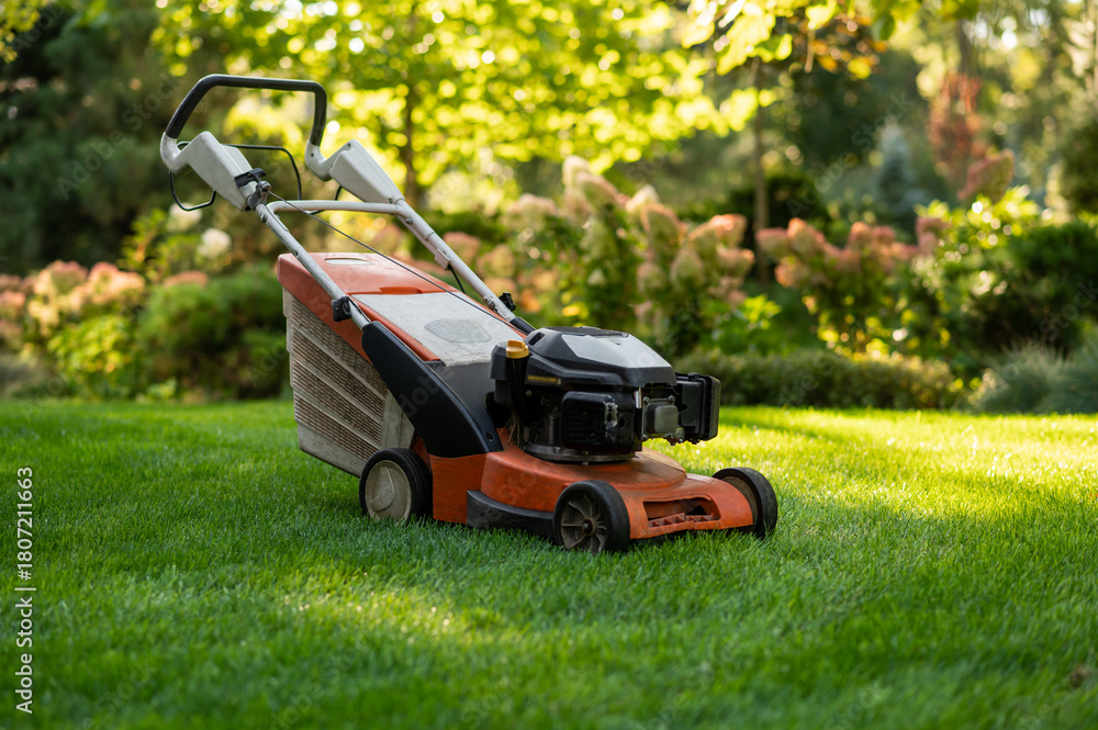 Fototapeta premium Modern lawnmower positioned outdoors on lawn