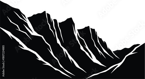 Dramatic black and white mountain range with sharp peaks against a bright sky.