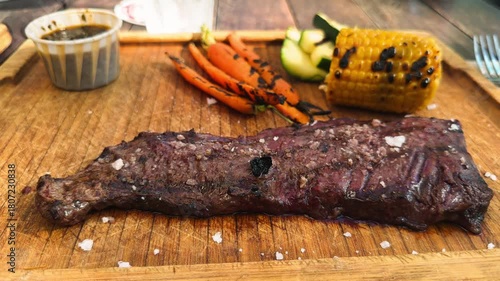 Skirt steak with grilled vegetables, corn, carrots and zucchini with sauce chimichurri. High quality 4k footage