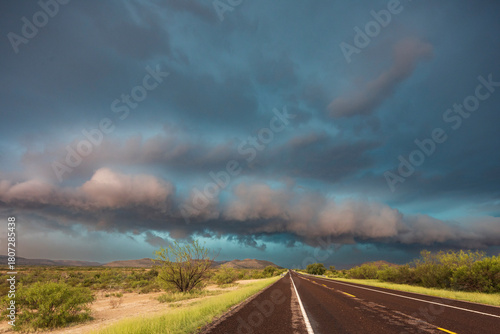 View of a road reaching the horizon, with black storm clouds above the road, the Texas Highway 90