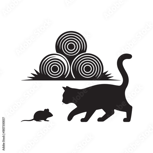 Silhouette of a cat stalking a mouse near hay bales