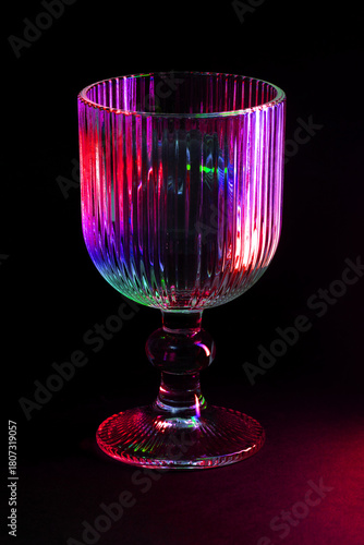 Colorful Lit Glass Goblet with Intricate Details in Dark Ambiance