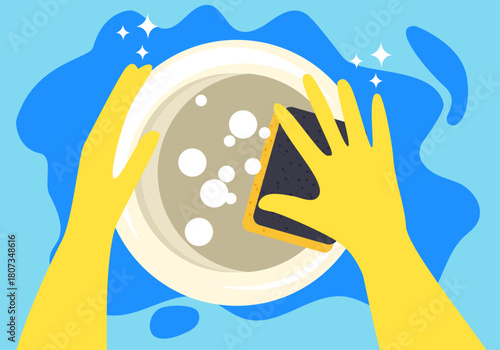 Hands in a yellow rubber gloves with cleaning sponge washing a dish on a blue background with a copy space