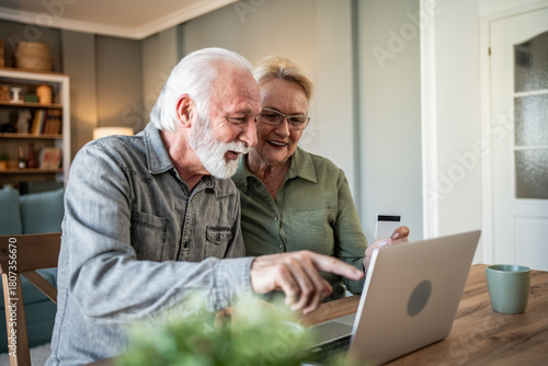 Senior couple enjoying online shopping and paying with credit card