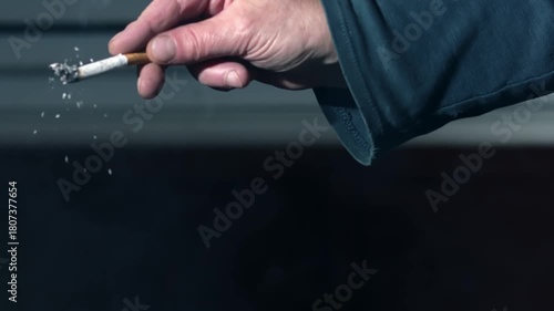 Hand flicking ash of cigarette 