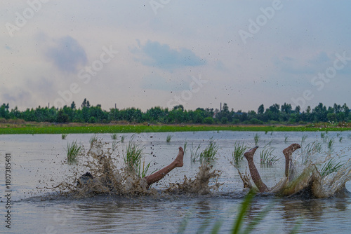 Vietnamese Youth Playing Football in Flooded Rice Field