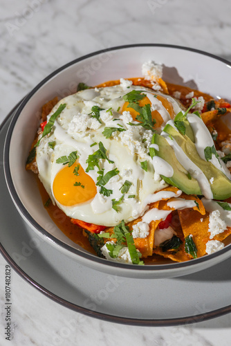 chilaquiles with fried eggs in hard light