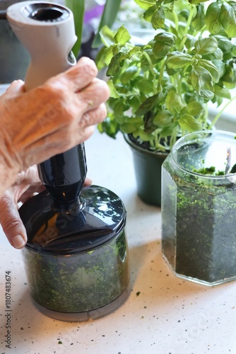 The process of preparing pasta with pesto from spinach, basil, green peas and green parsley: mixing the leaves