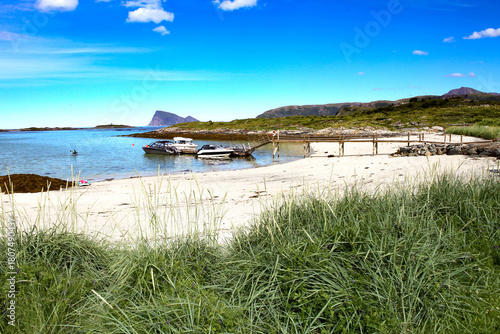 White sand beach in Sommaroy island, Northern Norway. Arctic stunning and idyllic Sommaroya beach with docked boats in summer time.