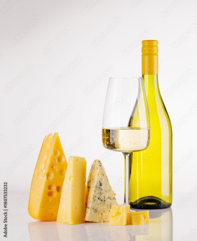 Fototapeta premium Assorted cheeses and wine bottle on white background