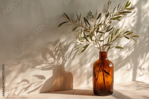 Elegant Olive Branches Displayed in a Vintage Amber Vase on a Warm, Textured Wall