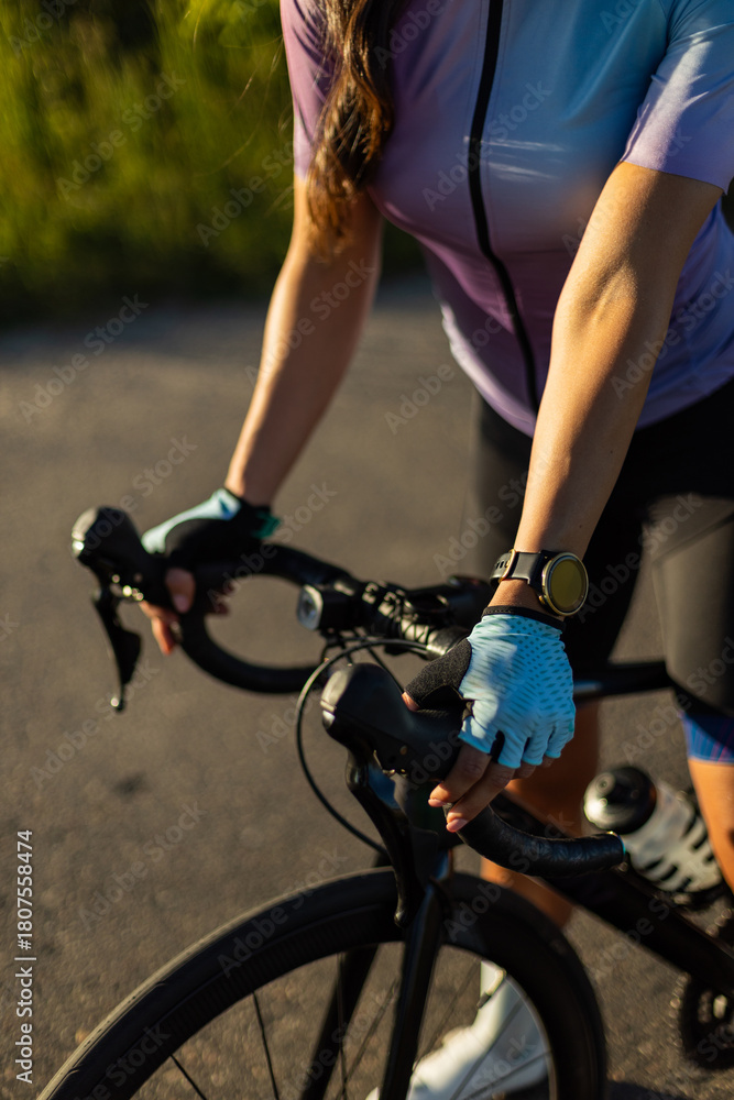 Naklejka premium Road Cyclist Riding Gracefully in the Golden Hour Light