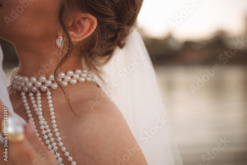Elegant bridal details with pearl necklace and soft romantic lighting