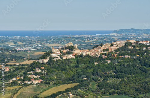 Elevated view of the hill town of Verucchio, Italy, overlooking rolling hills and the Adriatic Sea.