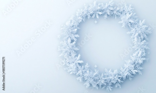 White snowflakes forming a circular winter wreath, creating a framing border on a light blue background for holiday themes