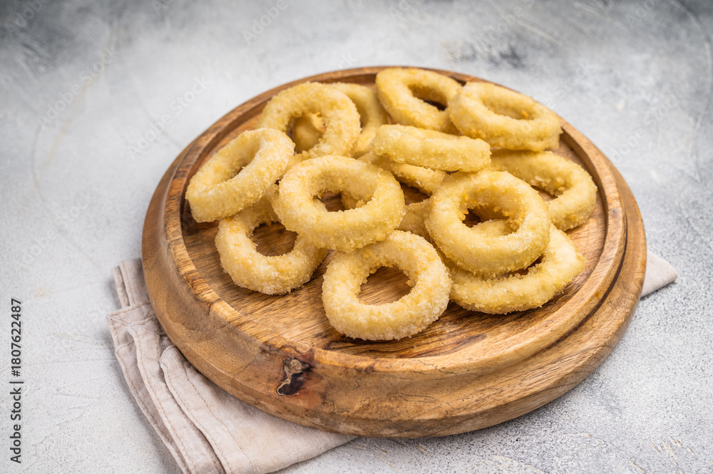 Naklejka premium Raw onion rings on wooden board. grey background. top view