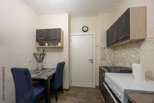 Interior of a modest kitchen in a rental apartment with table and chairs