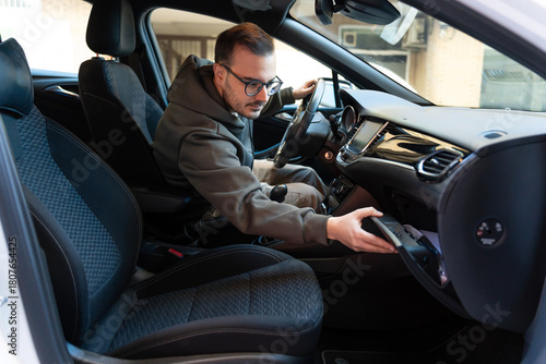 Man searching car glove compartment for documents