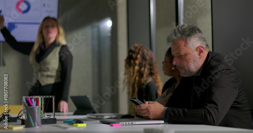 Bilde på lerret Businessman discreetly checking phone during office meeting as female colleague