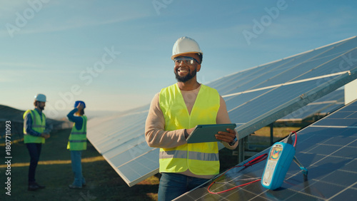 Solar panel technicians work on renewable energy project at sunset in a wide open field