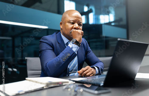 Canvastavla A mature African American businessman sitting at his desk, thinking seriously wh