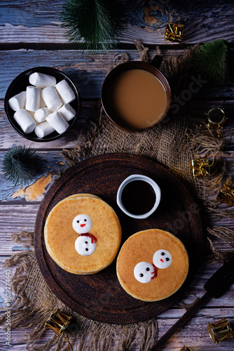 Pancakes with marshmallow snowmen in a plate for Christmas holidays