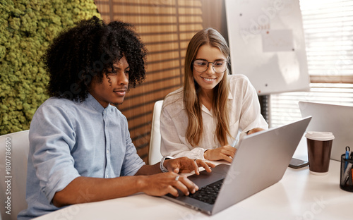 Team brainstorming with laptop in modern office