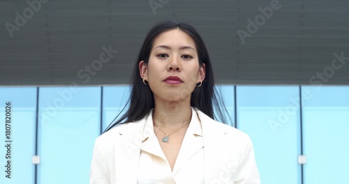 Serious portrait of a young Asian businesswoman looking directly at the camera, showing confidence and professionalism.