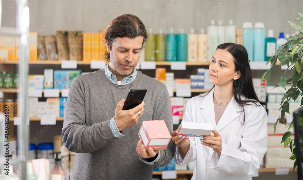 Fototapeta premium Man scans the packages with pills on mobile barcode, he reads detailed instructions on the pharmacy's website and looks at similar products. Purchase and payment for goods using a QR code