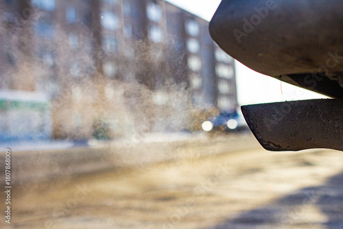 Close-up of car smoking exhaust pipe, car with gasoline engine. Gasoline engine warming up at idle in winter season. Blue exhaust smoke