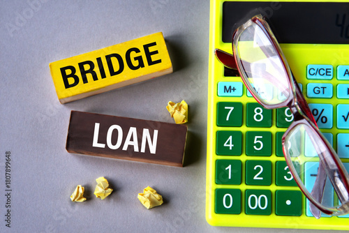 BRIDGE LOAN - words on wooden blocks with calculator and glasses in the background