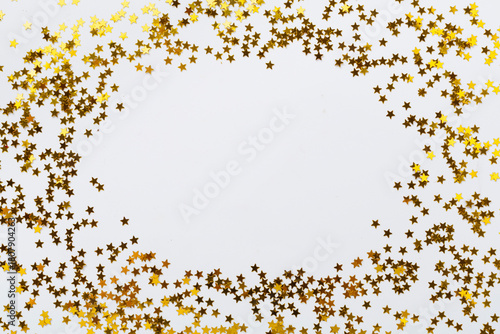 Golden star shape confetti on color background, top view