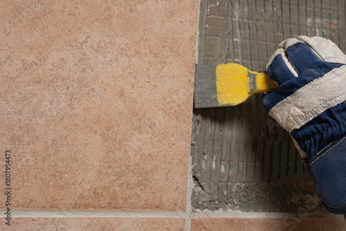 Denmark, november 2025, glove with chisel hammering tiles down