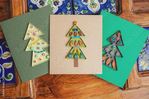a quilling cards with Christmas tree made of paper. making greeting cards. Hand made of paper quilling technique. Handicraft at home. Hobby, home office.