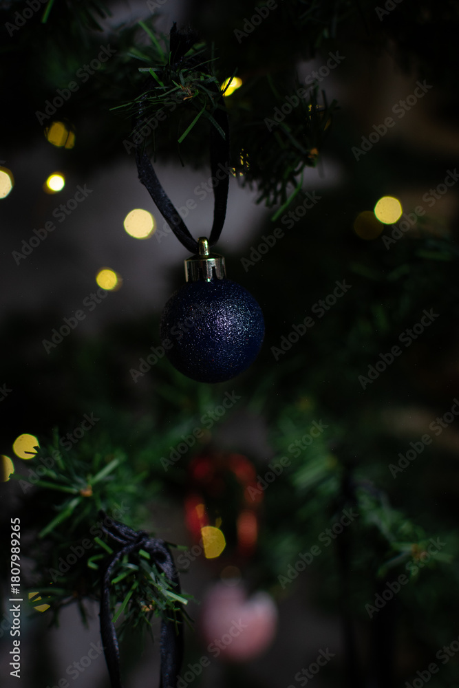 Naklejka premium close up of Christmas ornaments on a green christmas tree, sparkly textured christmas tree baubles on artificial tree