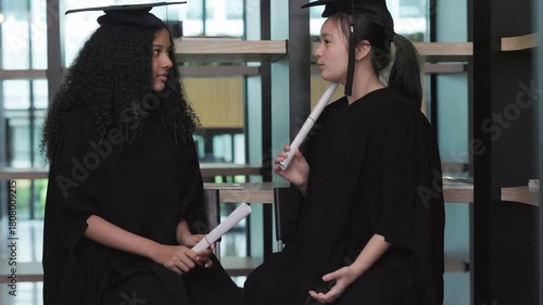 Two teenage girl students are happy on their graduation day.