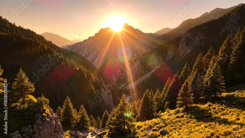 A stunning sunset illuminates the mountains as golden rays spread over the green trees. The mountains and trees create a picturesque landscape, reflecting the beauty of nature.