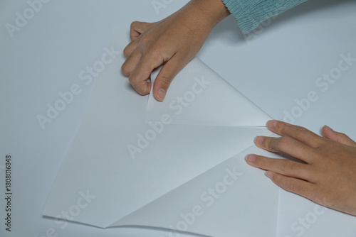Photography Hands folding white paper for origami