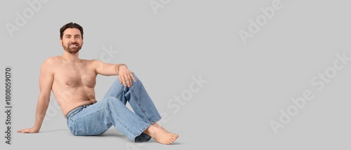 Bearded man in jeans on gre...