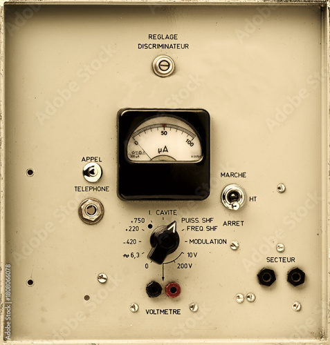 vintage electronic control panel detail with analog rotary dial, switchs and meter