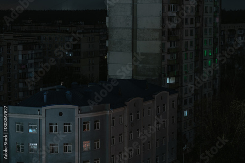 Night view of residential buildings in Ukraine during a blackout, with scarce illuminated windows
