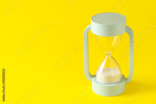 Hourglass on yellow backgro...
