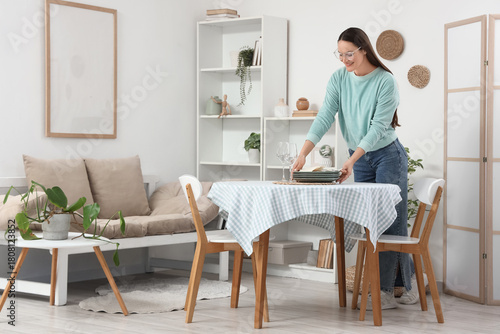 Young woman putting clean d...