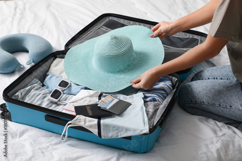 Young woman with hat packin...