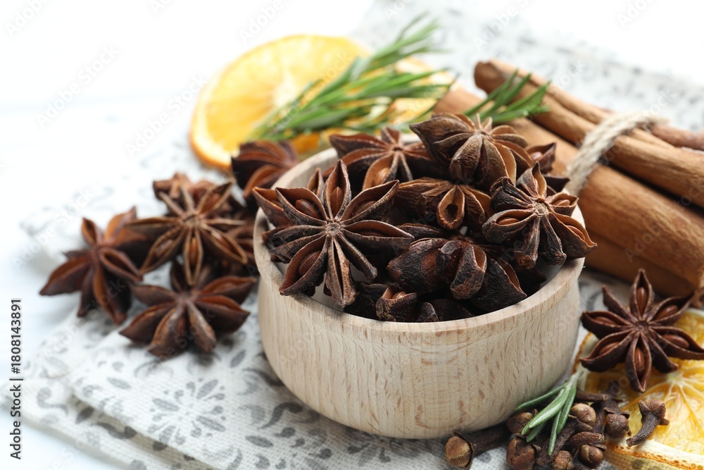 Fototapeta premium Different spices, dry orange slices and fresh rosemary for mulled wine on table, closeup