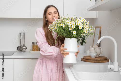 Young woman holding vase wi...