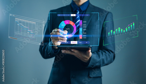Businessman using digital tablet with virtual data analytics dashboard, futuristic charts, and graphs for business intelligence, data visualization, and financial performance analysis.