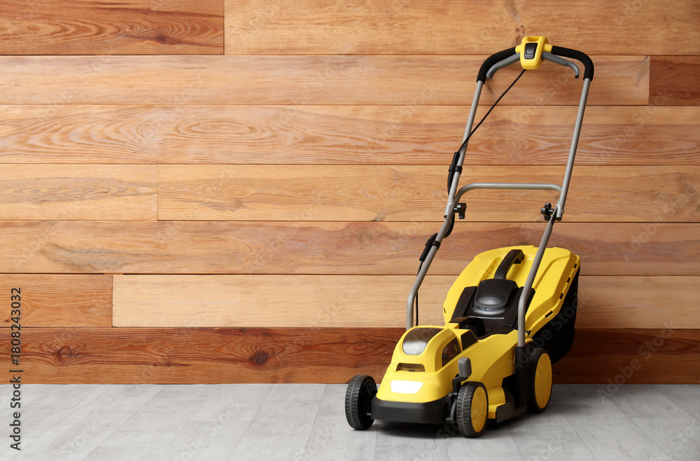 Obraz premium Lawn mower near wooden wall in room
